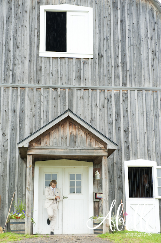 Outdoor groom portrait in front of barn