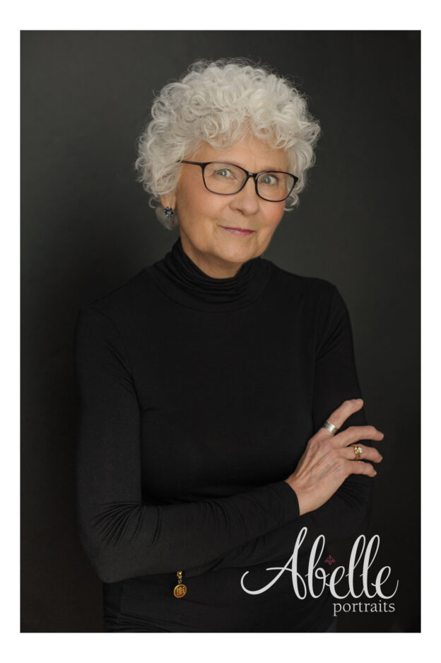 Book author headshot. Black turtleneck on black backdrop.